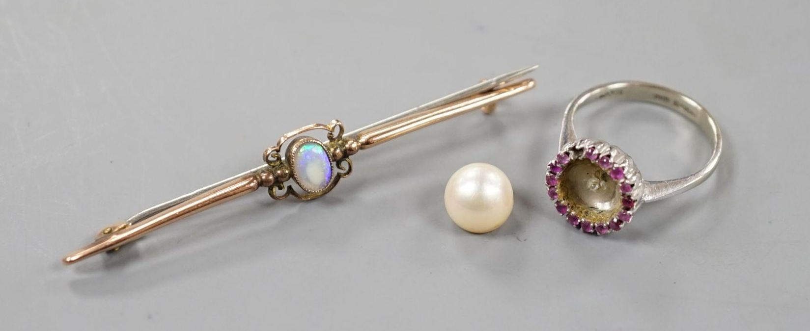 A modern Italian 18ct white gold, cultured pearl and ruby cluster set dress ring (pearl loose and missing one ruby), size N, gross 3.9 grams and a 9ct and white opal set bar brooch, gross 2.2 grams.